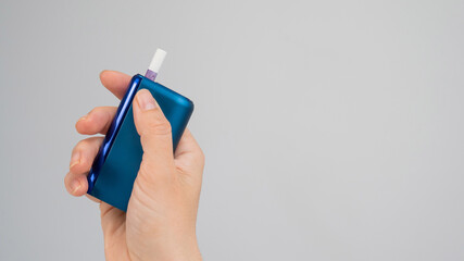 Woman holding electronic cigarette on white background. Tobacco heating systems.