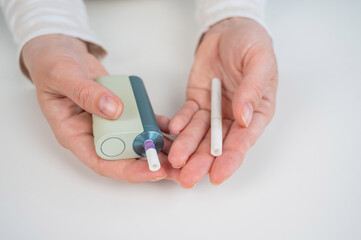 Woman holding regular and electronic cigarette on white background. Tobacco heating systems.