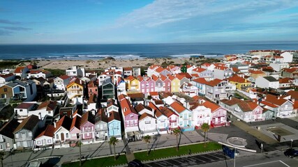 Aerial view of colorful beach huts along coastline, Portugal.