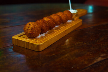 Crispy fried appetizers arranged on a wooden serving board, ready to eat and enjoy.