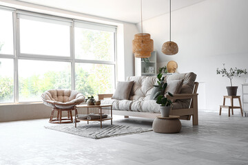 Interior of light living room with sofa, armchair and table