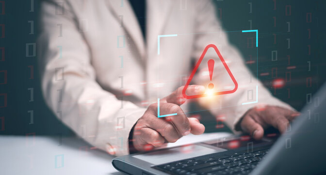 Cyber security. Businessman using computer laptop with triangle caution warning sign for notification error and maintenance concept. Hacker attacks and hacking data. Ransomware. Phishing. Spyware.
