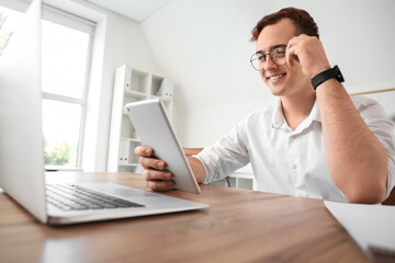 Young businessman working with tablet computer in office