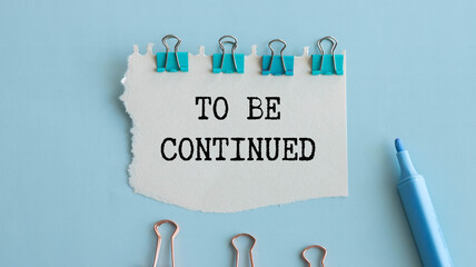 To Be Continued text message and alarm clock on wooden background