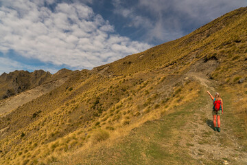 Rear view of hiker enjoying the  views of lake Hawea from the Isthmus track walkway
