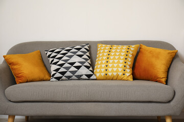 Cozy grey sofa with soft cushions in interior of modern living room