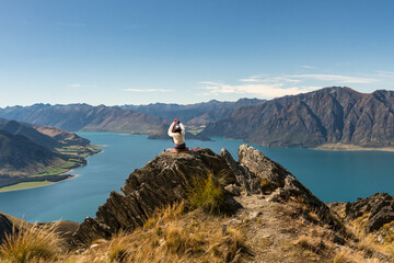 Rear view of hiker enjoying the  views of lake Hawea from the Isthmus track walkway