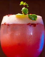 A beautifully presented pink cocktail garnished with fresh mint leaves, ideal for a summer party.
