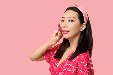 Beautiful Asian woman with lipstick on pink background