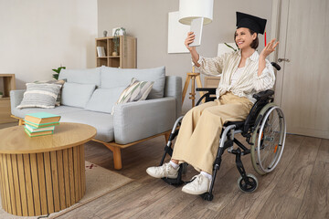 Female graduate in wheelchair with tablet computer video chatting at home
