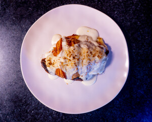 Melted cheese and sauce topping a golden croissant, ready to eat.