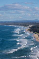 Obraz premium Aerial view of beach coastline with few waves.