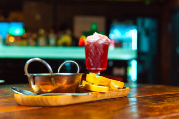 Enjoy a refreshing red cocktail with tasty appetizers at the bar.