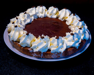 This coffee cake features a rich chocolate base, topped with whipped cream and coffee beans.