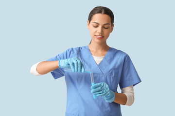 Happy female young scientist with test tubes of water samples on blue background