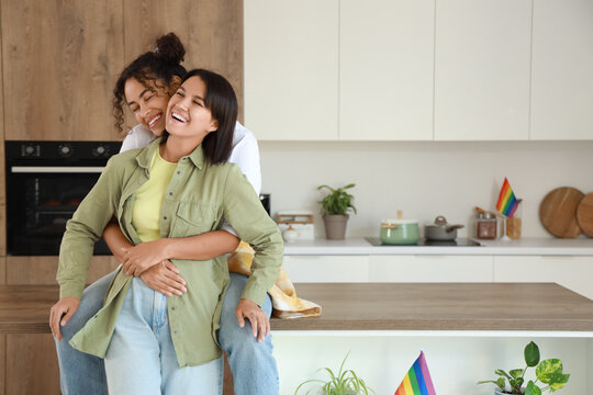 Young lesbian couple hugging in kitchen