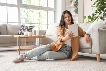 Beautiful woman using tablet computer at home in morning