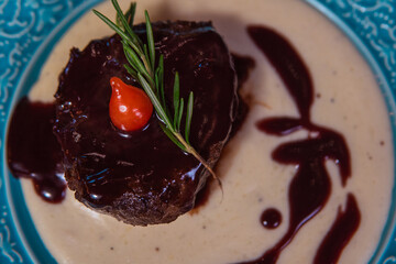 Exquisite beef tenderloin, drizzled with a dark sauce, and beautifully garnished.