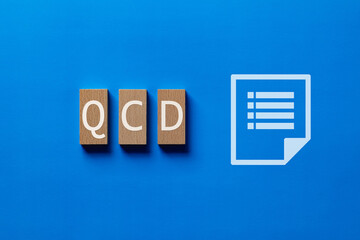 There is wood block with the word QCD. It is an abbreviation for Quality, Cost, Delivery as eye-catching image.