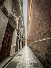 Empty narrow street in Valencia Ciutat Vella old town, Spain, the old town, flanked by ornate...