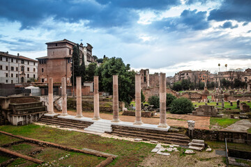 Wide aerial view of the Roman Forum (foro romano) ruins in Rome with standing columns, scattered...