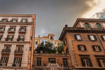 Late-afternoon light washes italian facades of early-20th-century apartment buildings in old...