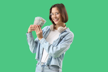 Young woman with money on green background