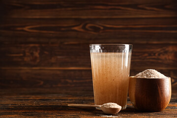 Glass of water with psyllium husk on wooden background