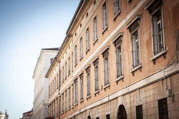 Oblique perspective of weathered 19th-century residential facade in Trieste old town, Italy, with...