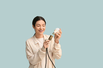 Female inventor inserting light bulb on blue background