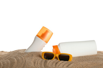Sunglasses and bottles of sunscreen cream on sand against white background
