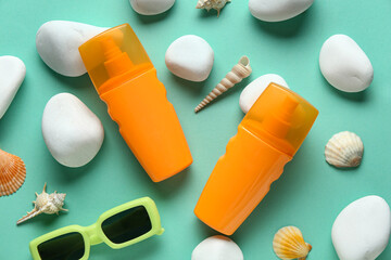 Obraz premium Composition with sunglasses, seashells, stones and bottles of sunscreen cream on turquoise background