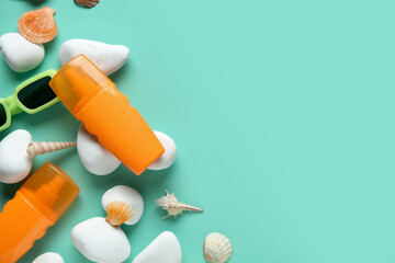 Composition with sunglasses, seashells, stones and bottles of sunscreen cream on turquoise...