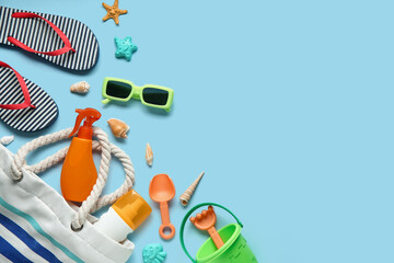 Composition with bag, bottles of sunscreen cream, seashells, sunglasses, toy shovel and rake on...