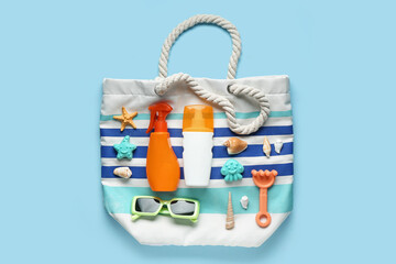 Composition with bag, sunglasses, decorative seashells, starfish and bottles of sunscreen cream on...