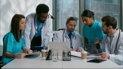 Fototapeta premium Teamwork group multiethnic team diverse doctors collaboration medical people brainstorming using laptop discuss illness medicine talking patient treatment analyzing health test results clinic cabinet