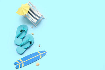 Composition with seashells, decorative deckchair, flip-flops, surfboard and umbrella on blue background