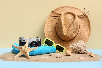 Composition with seashells, starfish, sunglasses, towel and sand on color background