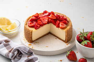 Sliced classic cheesecake with strawberries on light background. New York, Sicilian homemade...