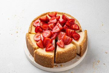 Sliced classic cheesecake with strawberries on light background. New York, Sicilian homemade...