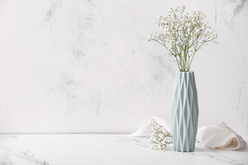 Vase with beautiful gypsophila flowers on marble background