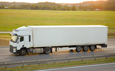 Modern White Freight Refrigeration Transport Truck Moving Through Open Landscape