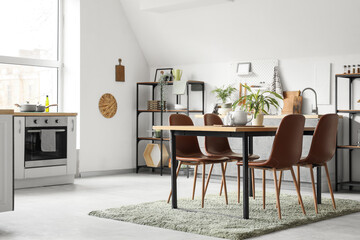 Interior of light kitchen with dining table and plants