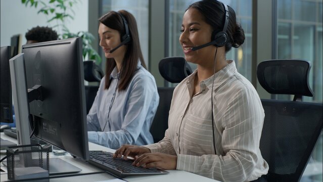 Happy multiethnic business agents operators working call center computer helpline diverse Indian Caucasian businesswomen African businessman headset speak phone online consultation callcenter office - Powered by Adobe