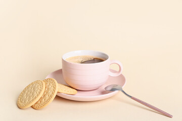 Sweet cookies and cup of hot coffee on beige background
