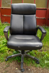 discarded black office chair in alley