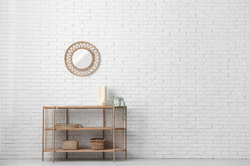 Shelving unit and mirror on white brick wall in room