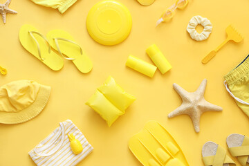 Composition with starfishes, clothes and beach accessories on yellow background