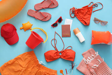 Composition with swimsuit and beach accessories on blue background, closeup
