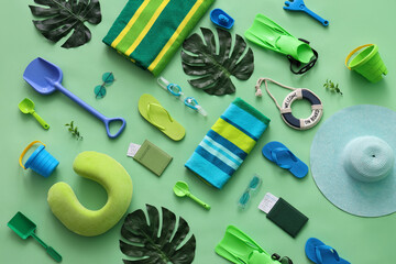Composition with tropical leaves and beach accessories on green background, closeup